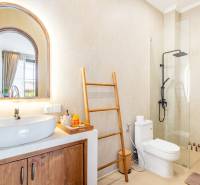 Badezimmer in der Villa mit Waschbecken, Dusche und Handtuchhalter in Leiterform.