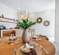 Ein gedeckter Tisch in einer Villa mit Holzdekorboden und Küchenzeile.