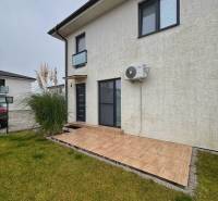 Eine 3-Zimmer-Wohnung in Kráľovianky hat eine Terrasse und eine Rasenfläche mit einer grauen Fassade.