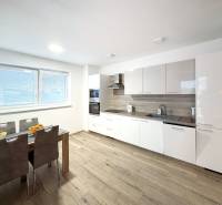 Küche in einer 3-Zimmer-Wohnung mit moderner Küchenzeile und Boden in Holzoptik.