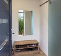 3-Zimmer-Wohnung mit Schuhbank, Spiegel und Boden in Holzoptik.