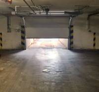 Das halb geöffnete Garagentor führt nach draußen, die Umgebung ist von indirektem Licht beleuchtet.