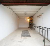 Geräumiges Inneres einer Garage mit Metallregalen und weißen Wänden.