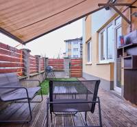 Terrasse in einer 2-Zimmer-Wohnung mit Holzboden, Außenbereich und Markise.