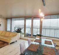 Wohnzimmer in einer 3-Zimmer-Wohnung mit heller Couch, Tisch und Glastüren.