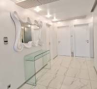 Innenraum einer 3-Zimmer-Wohnung mit glänzenden Fliesen, Spiegel und Glastisch.