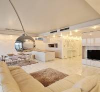 Innenraum einer 3-Zimmer-Wohnung mit offener Küche und weißem Sofa.