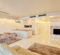 Wohnzimmer mit Kücheninsel, Esstisch und Fernseher in einer 3-Zimmer-Wohnung.