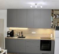 Küche in einer 2-Zimmer-Wohnung mit dunkelgrauer Küchenzeile und Geräten.