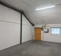 Innenraum der Produktionsräume mit weißen Wänden und einem Fenster mit Gitter.