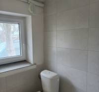 Toilette mit Wandfliesen in Produktionsräumen.