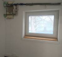 Ein Raum mit einem Fenster und einem Rohr an der Wand in einem Produktionsbereich.