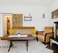 Wohnzimmer in einem Einfamilienhaus mit Kamin, gestreiftem Sofa und Couchtisch.