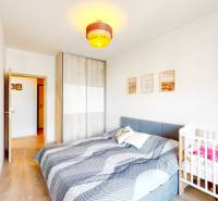 Schlafzimmer in einer 3-Zimmer-Wohnung mit Bett, Kinderbett und Schrank.