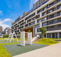 Der Außenbereich des Wohnkomplexes in Bratislava-Petržalka mit Spielplatz und Grünflächen.