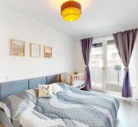 Helles Schlafzimmer mit Bett, Kinderbett und Holzboden in einer 3-Zimmer-Wohnung.