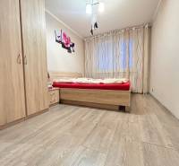 Schlafzimmer in einer 2-Zimmer-Wohnung mit Holzboden, Bett und Kleiderschrank.
