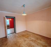 Ein Zimmer in einer 2-Zimmer-Wohnung mit einem Boden in Holzoptik und einfacher Beleuchtung.