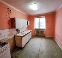 Die Küche in einer 2-Zimmer-Wohnung mit orangefarbenen Wänden und einer einfachen Küchenzeile.