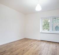 Ein Zimmer in einem Einfamilienhaus mit Steckdosen und einem Boden in Holzoptik.