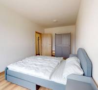 Schlafzimmer in einer 3-Zimmer-Wohnung mit Bett, Kleiderschrank und Boden in Holzoptik.