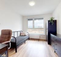 Ein Zimmer mit Holzboden, einem Schreibtisch und einem Sofa in einer 3-Zimmer-Wohnung.