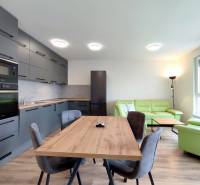 Helle Küche mit Esstisch und Sofa in einer 3-Zimmer-Wohnung mit Holzboden.