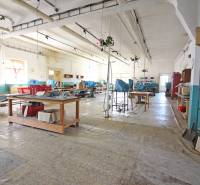 Das Innere des Gebäudes mit einer großen Halle, Arbeitstischen und Regalen.