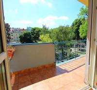 Balkon einer 3-Zimmer-Wohnung mit Blick auf Grünflächen und weitere Gebäude.