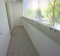 Veranda mit Glaswänden, Terrakottafliesen, Jalousien und Aussicht, geeignet für eine 3-Zimmer-Wohnung.