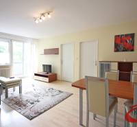 Wohnzimmer in einer 3-Zimmer-Wohnung mit Holzboden, Sofa und Esstisch.