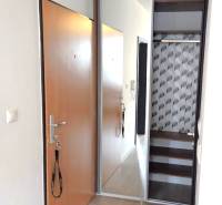 Flur in einer Einzimmerwohnung mit Schiebetüren und Einbauschrank.