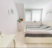 Schlafzimmer in einem Einfamilienhaus mit Holzdekorboden und hellen Möbeln.