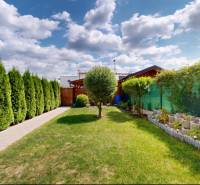 Der Garten eines Einfamilienhauses in Stupava mit gepflegtem Rasen und Bepflanzung.