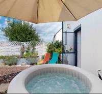 In einem Einfamilienhaus in Stupava gibt es einen Whirlpool mit einer Terrasse unter einem Sonnenschirm.