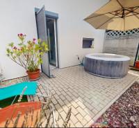 Im Außenbereich eines Einfamilienhauses in Stupava gibt es Liegestühle, einen Whirlpool und einen Sonnenschirm.