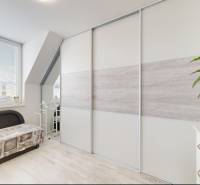 Innenraum eines Einfamilienhauses mit einem hellen Raum, einem Sofa und einer Pflanze, Boden mit Holzdekor.