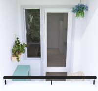 Balkon in einer 3-Zimmer-Wohnung in Bratislava - Petržalka mit Pflanzen und hängender Dekoration.