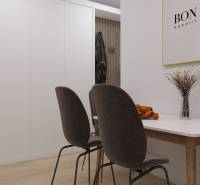 Ein helles Esszimmer mit dunklen Stühlen und Tisch, Boden mit Holzdekor.