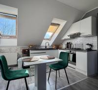 Küche in einer 2-Zimmer-Wohnung mit Holzboden und einem Tisch mit Stühlen.