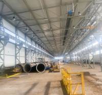 Produktionsräume mit Metallkonstruktionen und Rohrleitungen, Dobšiná. Breite Halle mit gelben Absperrungen.