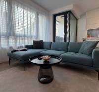 Wohnzimmer mit Sofa, Tisch und Küchenzeile in einer 2-Zimmer-Wohnung.