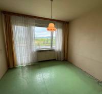 Ein Zimmer mit grünem Boden und großem Fenster in einer 3-Zimmer-Wohnung.