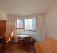 Garçonniere mit Sofa, Tisch und Schrank, Boden mit Holzdekor.