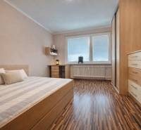 Schlafzimmer in einer 4-Zimmer-Wohnung mit Holzboden und Einbaumöbeln.