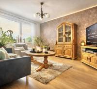 Wohnzimmer mit Sofa, Holzmöbeln und Boden mit Holzdekor in einer 4-Zimmer-Wohnung.