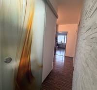 Ein Flur mit einem Boden in Holzoptik und interessanten Schiebetüren in einer 4-Zimmer-Wohnung.