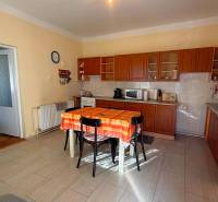 Eine Küche in einem Einfamilienhaus mit Holzdekor und einem orangefarbenen Tischtuch auf dem Tisch.