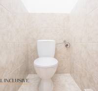 Eine Toilette mit hellen Fliesen in einem Gebäude.