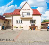 Ein Gebäude mit rotem Dach und reserviertem Parkplatz in Dunajská Streda.